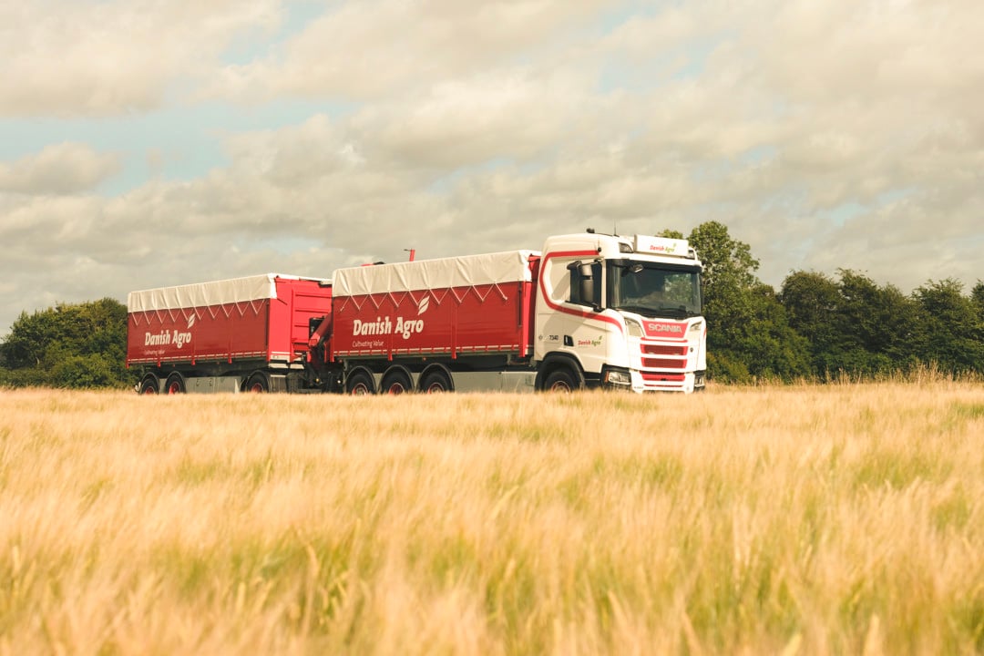 Danish Agro lastbil med rød tippevogn på kornmark